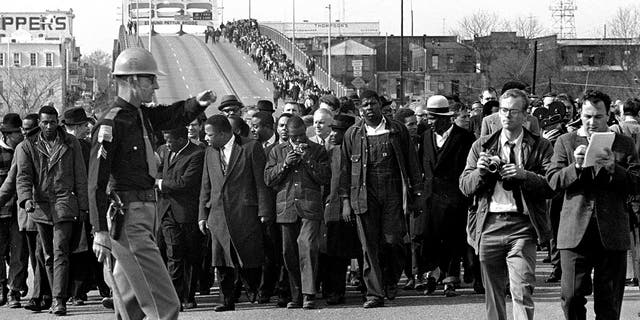 In this file photo dated March 10, 1965, demonstrators, including Dr.  Martin Luther King Jr., during a suffrage march over an Alabama bridge on the Selma, Ala, city limits.  King's participation in the 54-mile march from Selma, Ala., To the state capital, Montgomery, raised awareness of the problems blacks faced when registering to vote.  (AP photo / file)