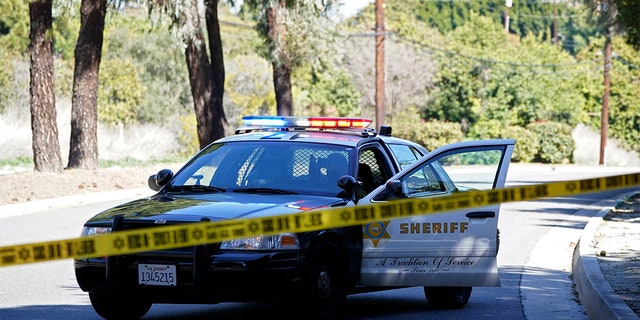 A police car blocks a road near a rollover accident involving golfer Tiger Woods Tuesday, Feb. 23 in the Rancho Palos Verdes section of Los Angeles. Woods had to be extricated from the vehicle with the "jaws of life" tools, the Los Angeles County Sheriff's Department said in a statement.
