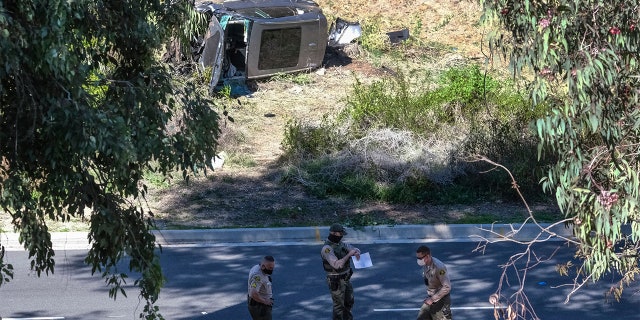 A vehicle rests on its side after a rollover accident involving golfer Tiger Woods along a road in the Rancho Palos Verdes section of Los Angeles on Tuesday, Feb. 23, 2021. Woods suffered leg injuries in the one-car accident and was undergoing surgery, authorities and his manager said. (AP Photo/Ringo H.W. Chiu)