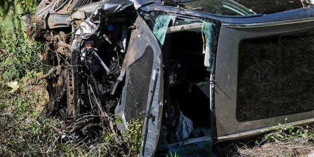 A vehicle rests on its side after a rollover accident involving golfer Tiger Woods along a road in the Rancho Palos Verdes section of Los Angeles on Tuesday, Feb. 23, 2021. Woods suffered leg injuries in the one-car accident and was undergoing surgery, authorities and his manager said. (AP Photo/Ringo H.W. Chiu)