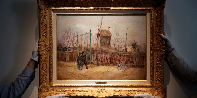 Sotheby's personnel display « Scene de rue à Montmartre » (Street scene in Montmartre), a painting by Dutch master Vincent van Gogh at Sotheby's auction house in Paris, Thursday, Feb. 25, 2021.  (AP Photo/Christophe Ena)