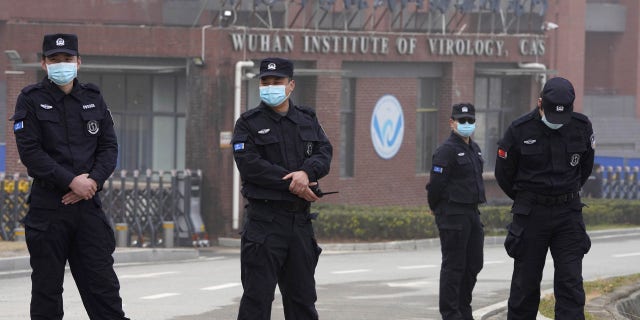 Security personnel gather near the entrance of the Wuhan Institute of Virology during a visit by the World Health Organization team in Wuhan in China's Hubei province on Wednesday, Feb. 3, 2021. 