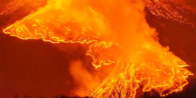 A fiery river of glowing lava flows on the north-east side of the Mt Etna volcano near Milo, Sicily, Wednesday night, Feb. 24, 2021. (AP Photo/Salvatore Allegra)