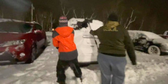 Abbey Meeker and Christian Stone shoveling out cars at Westerly Hospital in Rhode Island on Jan 1, 2020. (Courtesy WJAR)