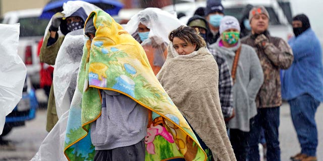 Customers waited over an hour in the freezing rain to fill their tanks. (AP Photo/David J. Phillip)