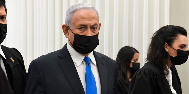 Israeli Prime Minister Benjamin Netanyahu stands at a hearing at the district court in Jerusalem, Monday, Feb. 8, 2021. (AP Photo/Reuven Castro, Pool)