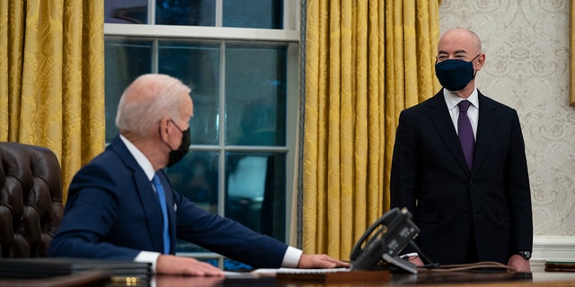 Le secrétaire à la Sécurité intérieure, Alejandro Mayorkas, écoute le président Joe Biden prendre la parole avant de signer un décret sur l'immigration, dans le bureau ovale de la Maison Blanche, le mardi 2 février 2021, à Washington.  (Photo AP / Evan Vucci)