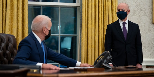 Le secrétaire à la Sécurité intérieure, Alejandro Mayorkas, écoute le président Joe Biden prendre la parole avant de signer un décret sur l'immigration, dans le bureau ovale de la Maison Blanche, le mardi 2 février 2021, à Washington.  (Photo AP / Evan Vucci)