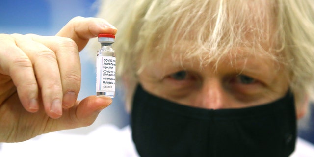 FILE - In this Wednesday, Feb. 17, 2021 file photo, Britain's Prime Minister Boris Johnson holds a vial of the Oxford/Astra Zeneca Covid-19 vaccine at a vaccination center in Cwmbran, South Wales. (Geoff Caddick/Pool via AP, File)
