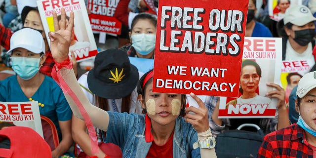 Anti-coup protesters display images of deposed leader Aung San Suu Kyi in Yangon, Burma, on Thursday. (AP Photo)