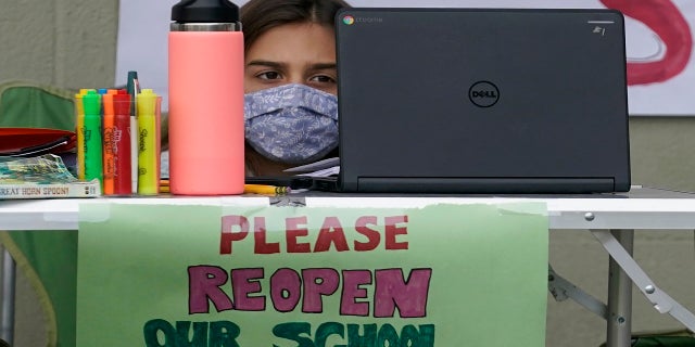 Clarendon Alternative Elementary School fourth-grader Ayla Einhorn works on her computer as students and parents attend distance learning Zoom classes at Midtown Terrace Playground in San Francisco on Thursday. (AP)