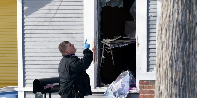 A Dallas police officer investigates a crime scene at a home on the 5300 block of Bonita Ave., where earlier in the day two other officers were shot responding to an emergency call in Dallas, Thursday, Feb. 18, 2021. (AP Photo/Tony Gutierrez)