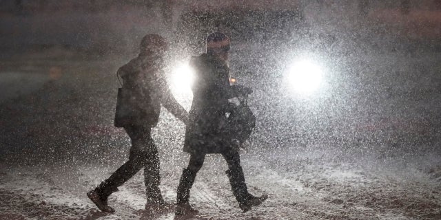 Pedestrians cross a street in Denver as heavy snowfall swept over the region Wednesday night. (AP)