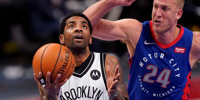 Brooklyn Nets Guard Kyrie Irving (11) versucht einen Layup, als das Detroit Pistons Center Mason Plumlee (24) während der ersten Hälfte eines NBA-Basketballspiels am Dienstag, 9. Februar 2021, in Detroit verteidigt. (AP-Foto/Carlos Osorio)