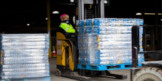 A worker transports bottles of water from the City of Houston Upper Braes Warehouse to delivery trucks on Thursday. (AP/Houston Chronicle)