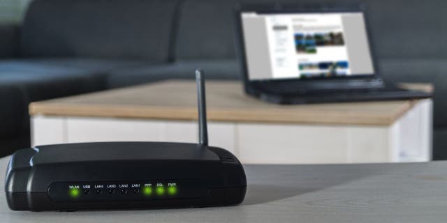 5 reasons to replace your old router 8 Home internet connection. A wlan router on desk with notebook in background.