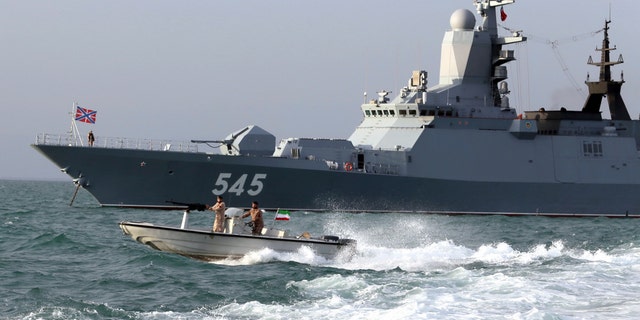 A Russian warship and an Iranian army speed boat attend a joint naval exercise on Tuesday. (AP/Iranian Army)