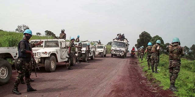 In this image from video, United Nations peacekeepers guard the area where a U.N. convoy was attacked. (AP Photo/Justin Kabumba)