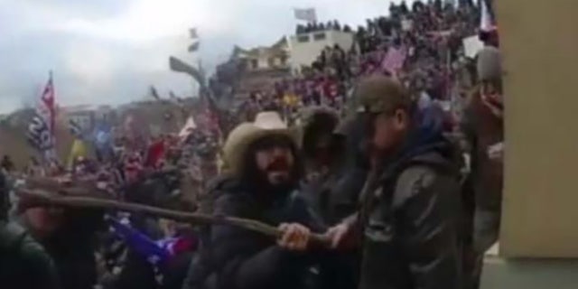Body camera footage showed Mellis in the same cowboy hat grabbing a stick before allegedly using it to strike officers.
