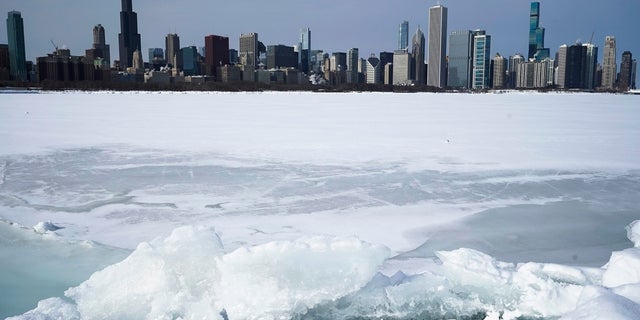 Lake Michigan is shown here Sunday covered with snow and ice, with the Chicago skyline in the background. The area is expected to get more than a foot of snow by the end of Tuesday. (AP)