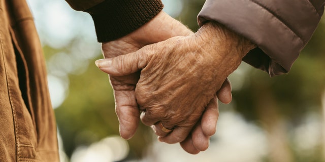 Elderly couple holding hands