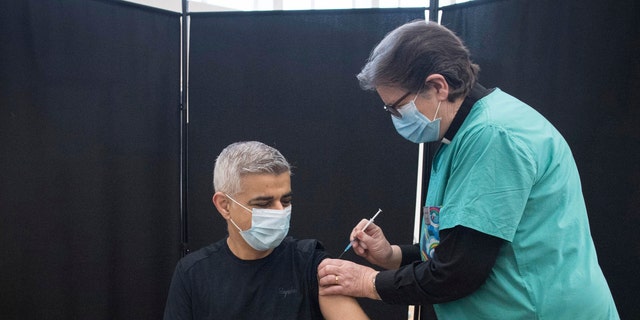 Mayor of London Sadiq Khan receives his first dose of the Pfizer coronavirus vaccine administered by Dr. Sue Clarke at a COVID-19 vaccination clinic at the Mitcham Lane Baptist Church in south London, Friday Feb. 19, 2021. (Stefan Rousseau/PA via AP)