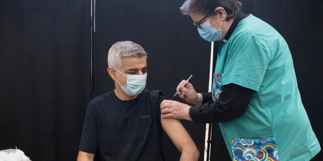 Mayor of London Sadiq Khan receives his first dose of the Pfizer coronavirus vaccine administered by Dr. Sue Clarke at a COVID-19 vaccination clinic at the Mitcham Lane Baptist Church in south London, Friday Feb. 19, 2021. (Stefan Rousseau/PA via AP)