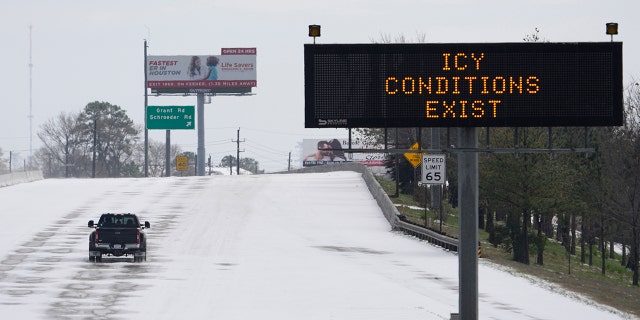 A truck drives past a highway sign Monday, Feb. 15, 2021, in Houston.