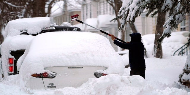 A man is shown brushing snow off a car. A good emergency supply kit has three days' worth of water and food per person. This means roughly 2,000 calories of food and a gallon of water for each person for each day.