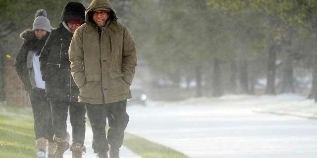 Erasmo Vazquez, right, walks along a snow covered sidewalk with his wife, Maria, center, and daughter Day, left, Monday, Feb. 15, 2021, in Houston.
