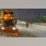A person waits for a snow plow to pass before crossing the street in Fort Lee, N.J., Monday, Feb. 1, 2021. Snowfall is picking up in the Northeast as the region braced for a whopper of a storm that could dump well over a foot of snow in many areas, create blizzard-like conditions and cause travel problems for the next few days. (AP Photo/Seth Wenig)