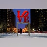 A person wearing a face mask as a precaution against the coronavirus walks during a winter storm near the Robert Indiana sculpture "LOVE" at John F. Kennedy Plaza, commonly known as Love Park, in Philadelphia, Monday, Feb. 1, 2021. (AP Photo/Matt Rourke)