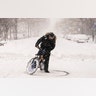 A cyclist on an electric bicycle does donuts on Broadway during a snowstorm, Monday, Feb. 1, 2021, in the Manhattan borough of New York. (AP Photo/John Minchillo)