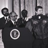 President Ronald Reagan is presented with a flight jacket by Lt. Colonel (Retired) Charles McGee, president of the Tuskegee Airmen Association, making Reagan an honorary member of the TAI, Washington, D.C., Feb. 2, 1984.