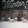 Outdoor dining tables and chairs are covered in snow during a snowstorm, Monday, Feb. 1, 2021, in New York.