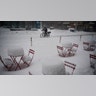 A man delivers food on his electric bicycle as he rides past snow-covered dining tables in Midtown during a snowstorm, Monday, Feb. 1, 2021, in New York.