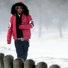 Igee Cummings walks through the snow Monday, Feb. 15, 2021, in Houston. A winter storm dropping snow and ice sent temperatures plunging across the southern Plains, prompting a power emergency in Texas a day after conditions canceled flights and impacted traffic across large swaths of the U.S.