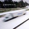 An 18-wheeler speeds along an ice covered Interstate 55 in north Jackson, Miss., Monday, Feb. 15, 2021, as light snow mixed with sleet, and rain continue to cover much of the state. While the highway has several lanes, some drivers preferred to follow an established trail. The National Weather Service forecasts temperatures barely hovering at 20 degrees Fahrenheit, and likely slipping into the single digits by Tuesday morning. A winter storm warning continues throughout the state. Although most of the motorists drove cautiously under the speed limit, others chose to drive at close to posted highway speeds.