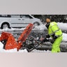 Mario Vieira, a custodian at the Beatrice H. Wood Elementary School in Plainville, Mass., struggles with a snowblower Tuesday, Feb. 2, 2021, while clearing sidewalks and walkways after the area received a blanket of wet, heavy snow overnight.