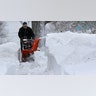 A man uses a snow thrower to clear a sidewalk after a snowstorm Tuesday, Feb. 2, 2021, in Marlborough, Mass.