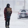 Cars drive by Michael Given as he stands at an intersection asking for money during a winter storm Sunday, Feb. 14, 2021, in Oklahoma City. Given said he is a restaurant worker who was laid off during the coronavirus pandemic.