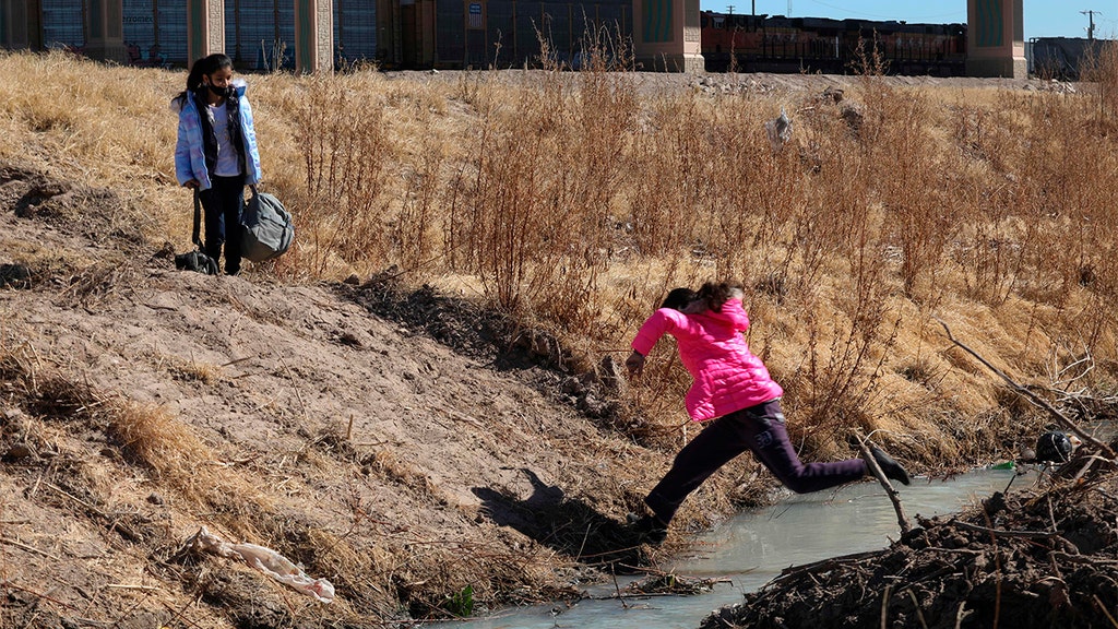 KID JUMPING OVER STREAM