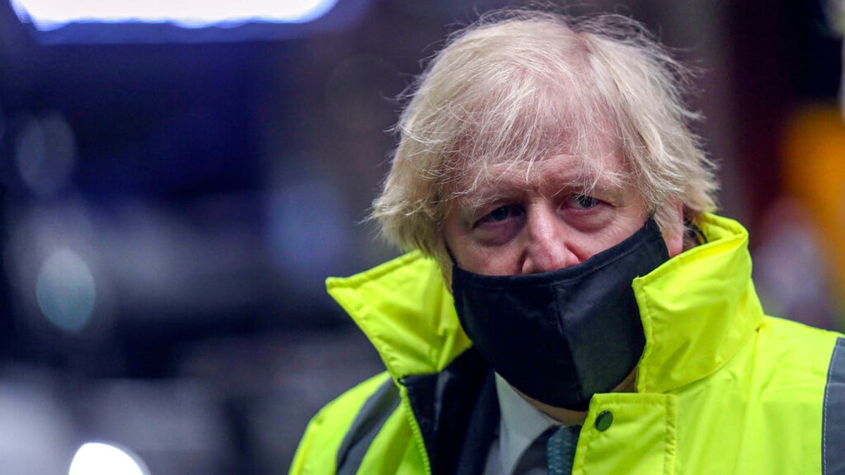 Britain's Prime Minister Boris Johnson visits the National Express depot in Coventry, central England, Monday March 15, 2021. (Steve Parsons/Pool via AP)