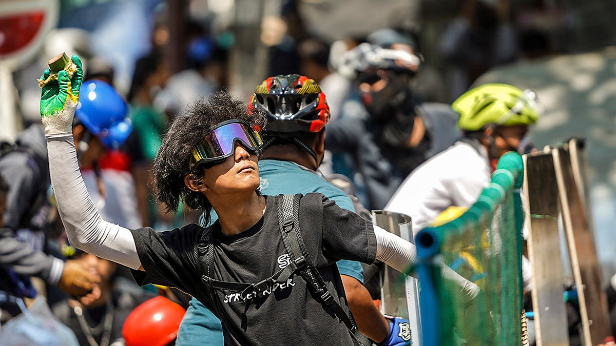 A protester prepares to throw a part of a banana toward the police during a protest against the military coup in Yangon, Burma, Tuesday, March 2, 2021. (AP Photo)
