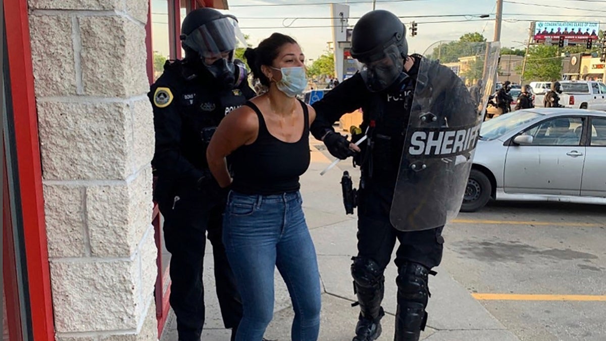 Police officers are shown arresting Des Moines Register reporter Andrea Sahouri after a Black Lives Matter protest she was covering on May 31, 2020, in Des Moines, Iowa, was dispersed by tear gas.(Photo courtesy Katie Akin via AP)