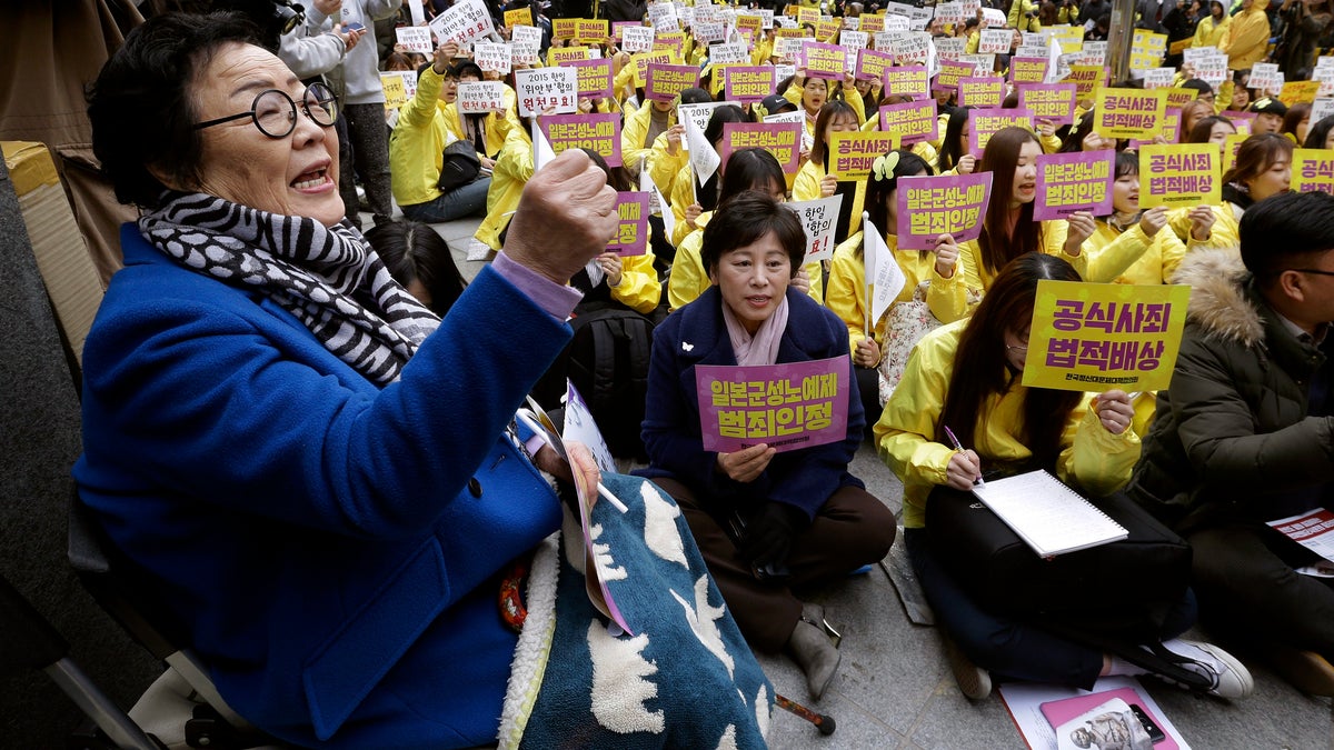 FILE - In this March 1, 2017, file photo, former "comfort woman" Lee Yong-soo, left, who was forced to serve for the Japanese troops as a sex slave during World War II, shouts slogans during a rally to mark the March First Independence Movement Day, the anniversary of the 1919 uprising against Japanese colonial rule, near the Japanese Embassy in Seoul, South Korea. Harvard University law professor J. Mark Ramseyer alleged in a December 2020 article, scheduled to appear in the March 2021 issue of the International Review of Law and Economics, that the Korean women had actually chosen to work as prostitutes. Lee described Ramseyer's claim as "ludicrous" and demanded an apology. (AP Photo/Ahn Young-joon, File)