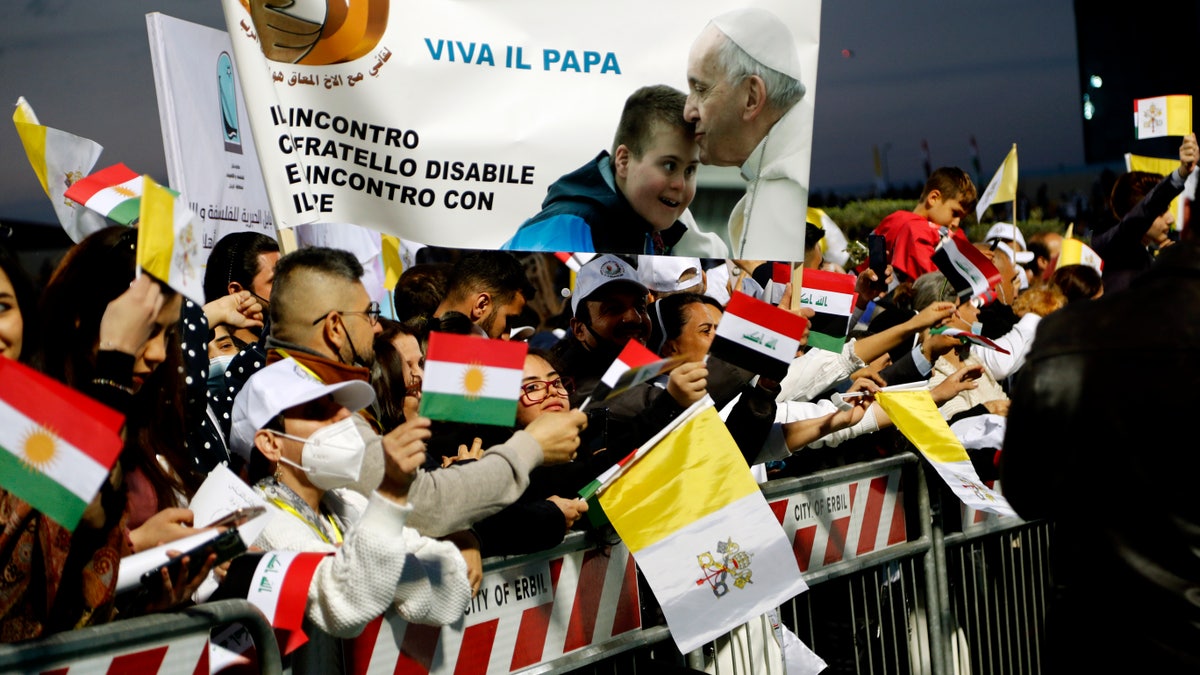 Iraqi Christians say goodbye to Pope Francis after an open air Mass at a stadium in Irbil, Iraq, Sunday, March 7, 2021. Thousands of people filled the sports stadium in the northern city of Irbil for Pope Francis' final event in his visit to Iraq: an open-air Mass featuring a statue of the Virgin Mary that was restored after Islamic militants chopped of the head and hands. (AP Photo/Hadi Mizban)