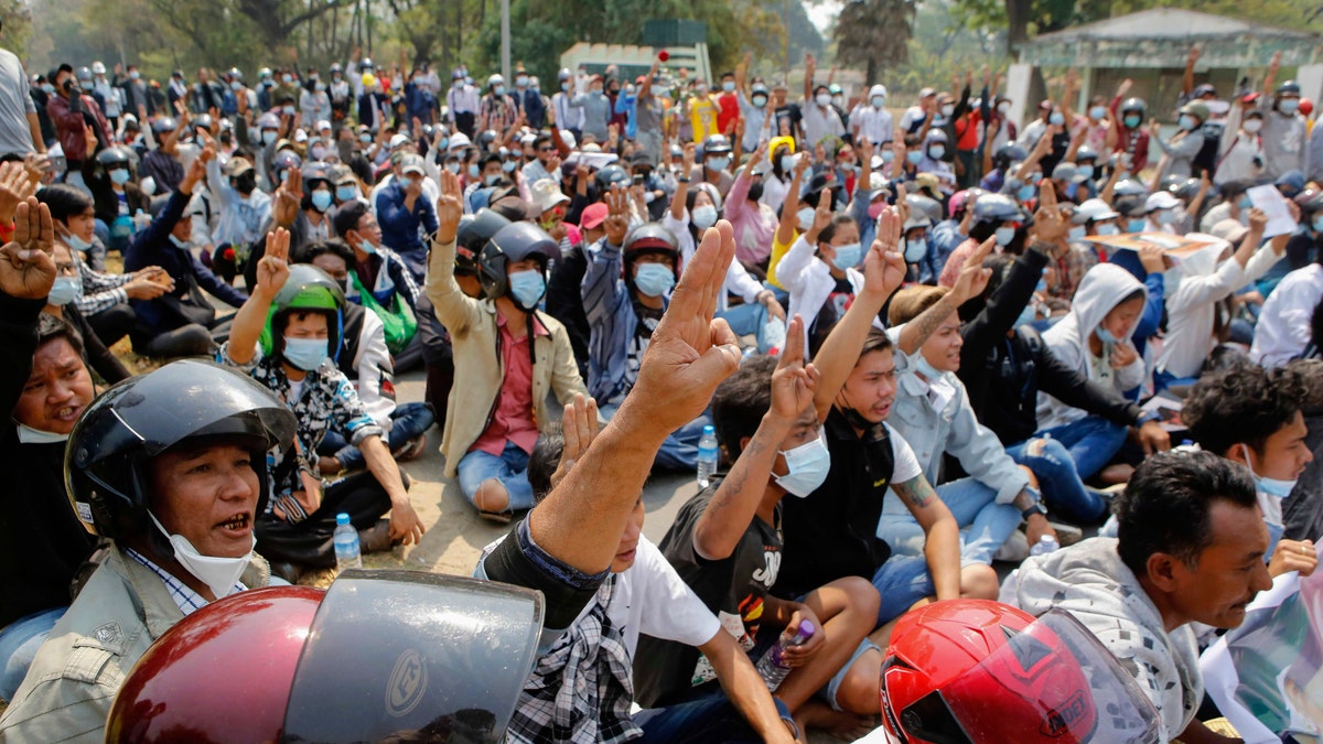 Anti-coup protesters flash a three-fingered sign of resistance during a demonstration in Naypyitaw, Burma, Monday, March 8, 2021. The escalation of violence in Burma as authorities crackdown on protests against the Feb. 1 coup is raising pressure for more sanctions against the junta, even as countries struggle over how to best sway military leaders inured to global condemnation. (AP Photo)