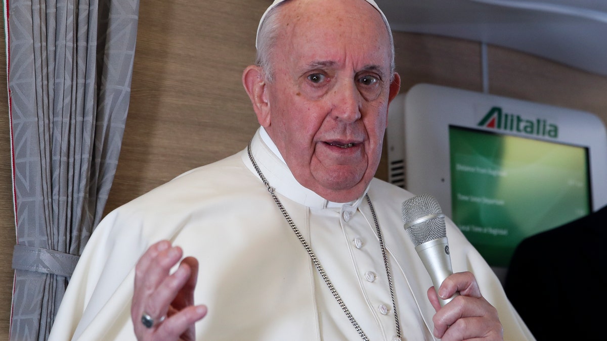 Pope Francis speaks to journalists, Monday, March 8, 2021, while flying back to The Vatican at the end of his four-day trip to Iraq where he met with different Christian communities and Shiite revered cleric Grand Ayatollah Ali al-Sistani. (AP Photo/Yara Nardi, pool)