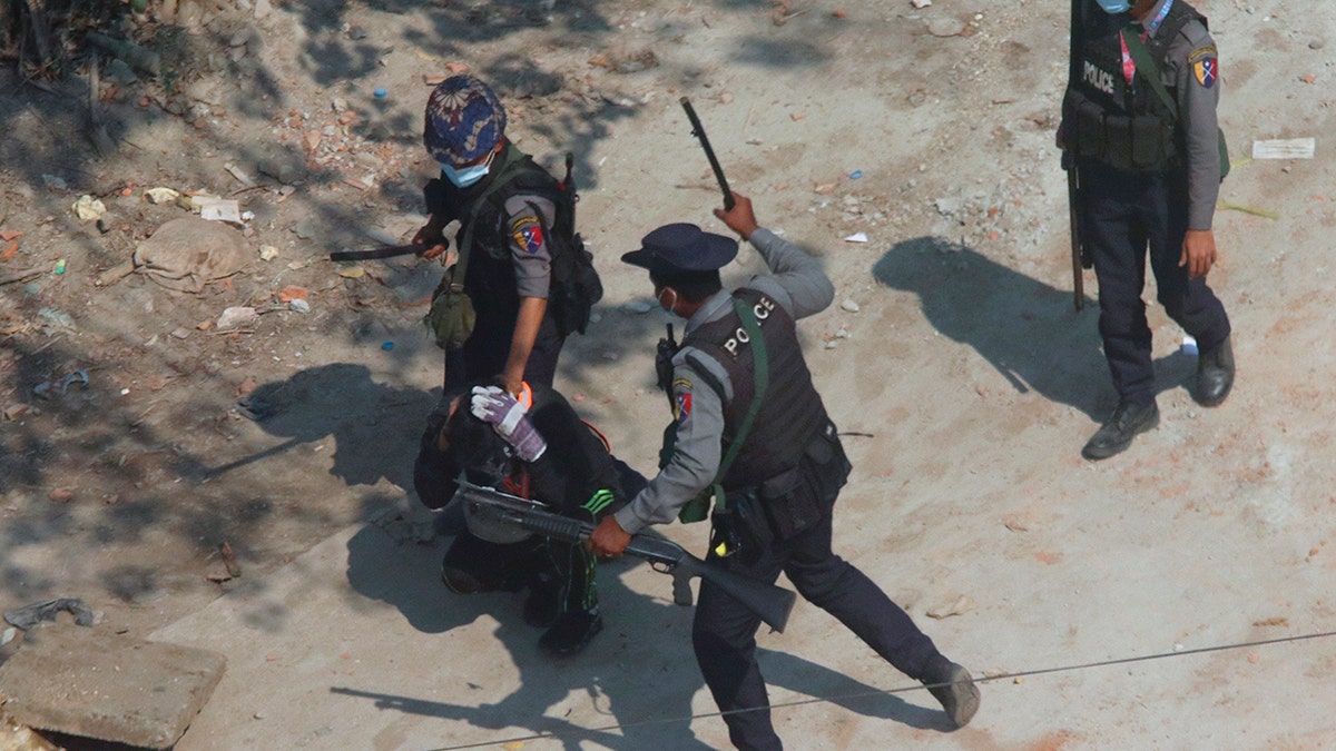 FILE - In this March 6, 2021, file photo, riot police officers hold down a protester as they disperse protesters in Tharkata Township on the outskirts of Yangon, Myanmar. (AP Photo/File)